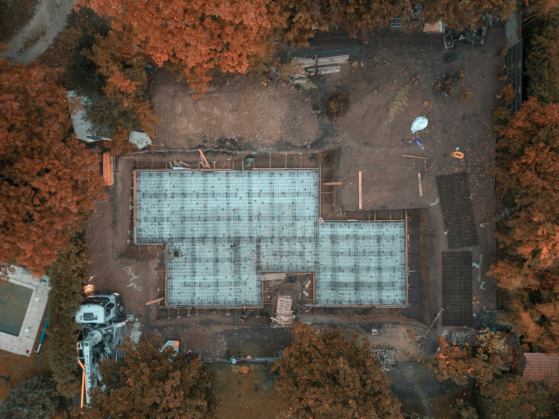 an aerial view of a pool surrounded by trees
